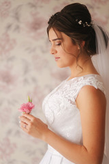 Charming bridehold a boutonniere in her hands