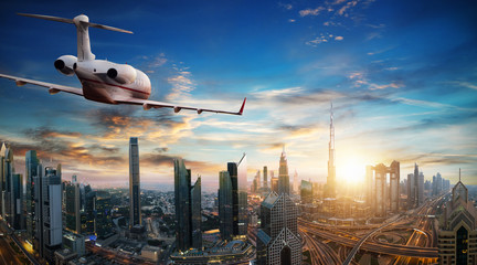 Obraz premium Private jet plane flying above Dubai city