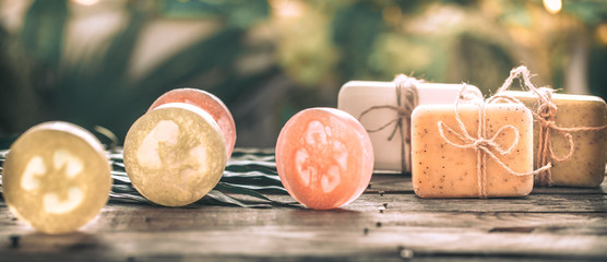 Spa handmade soap and a towel, the composition of the tropical leaves wooden background