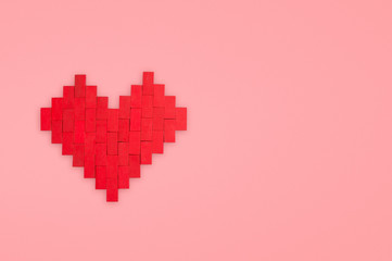 Heart made of toy bricks on a pink background. Valentine concept.