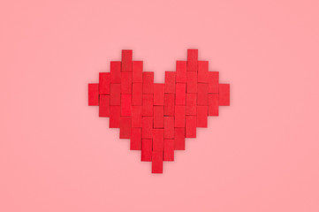 Heart made of toy blocks on a pink background. Valentine concept. 