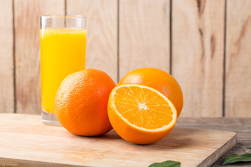 Glass of orange juice and fresh fruits on wooden background