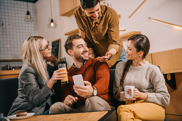 happy group of friends smiling while holding drinks