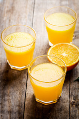 Freshly pressed orange juice, surrounded by fresh oranges
