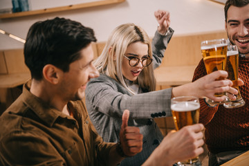 cheerful friends toasting with glasses of beer
