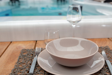 closeup on wooden frame around a hot tub with flatware for luxurious diners