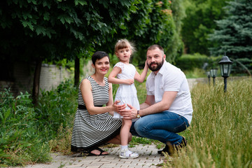 Happy young family spending time together outside in green nature.