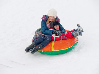 Winter fun. children ride from a snow hill.