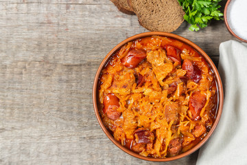 Braised cabbage with meat and smoked sausage. Traditional Polish and Lithuanian dishes. The view from the top. Copy-space.