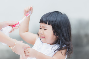 Adorable girl  against practice or learning for brush teeth.