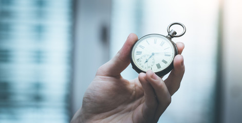 Time goes by: Man is holding a vintage watch in his hand, business context, copy space