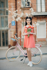 Romantic woman in pink dress and her a bicycle