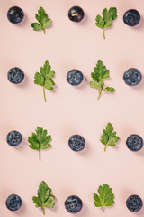 Pattern of blueberry and parsley leaves on pink background