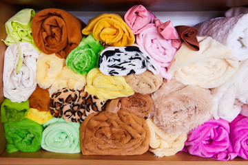 Pile of vibrant colorful rolled up fleece textile. Fabric for toys design