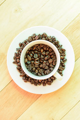 Coffee bean in the cup on wood plate