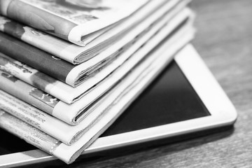 Newspapers and Tablet pc. Magazines and Journals with Headlines and Articles and Portable Electronic Device. Reading Business News on Paper Pages or on Screen of Mobile Computer in Internet