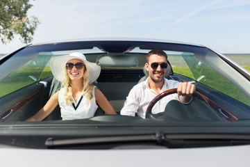 leisure, road trip, dating, couple and people concept - happy man and woman driving in cabriolet...