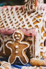 Gingerbread house and cookies in the form of men on the background of the Christmas tree
