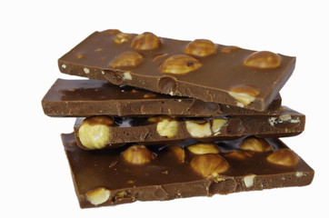 Chocolate pieces with hazelnuts isolated on white background. Hazelnut chocolate bar pieces tower 