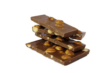 Chocolate pieces with hazelnuts isolated on white background. Hazelnut chocolate bar pieces tower 