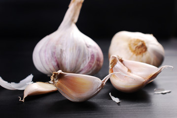 fresh garlics with cloves on black background