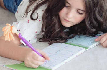 Niña escribiendo en su diario personal