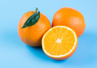 Orange slice. Fresh orange and half orange on blue background.