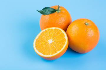 Orange slice. Fresh orange and half orange on blue background.