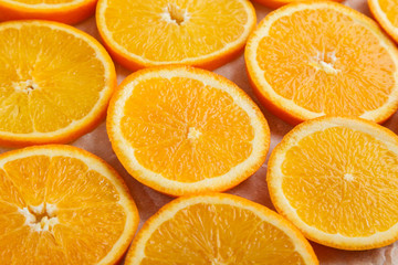 Abstract background with citrus orange slices on parchment paper. Close up. Top view. Studio photography.