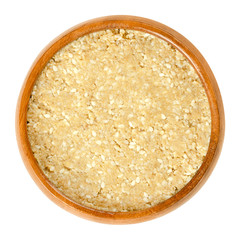 Homemade white tahini with sesame seeds in wooden bowl. Condiment made of ground husked sesame seeds. Dip or major ingredient in hummus, baba ghanoush or halva. Food photo closeup on white background.