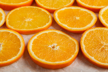Abstract background with citrus orange slices on parchment paper. Close up. Top view. Studio photography.