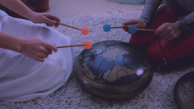 Young womеn playing the happy drum at home. 
