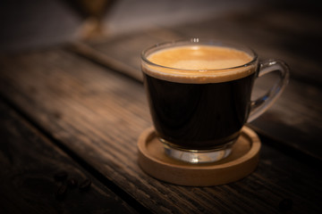 A cup of black coffee on wooden table in coffee shop