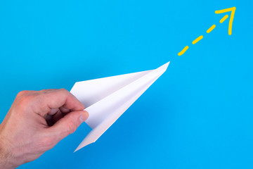 Travelling concept with hand holding paper plane.