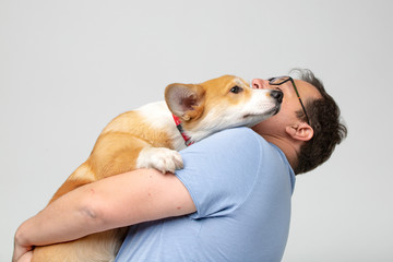 Adult man hold corgi dog