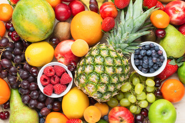 Healthy fruit background filled with strawberries raspberries oranges plums apples kiwis grapes blueberries mango persimmon pineapple, selective focus