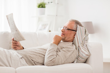 information, people and mass media concept - senior man reading newspaper at home