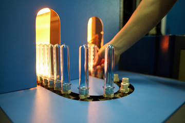 Pet bottle with natural water manufacturing. Soft focus. Worker's hands on the background