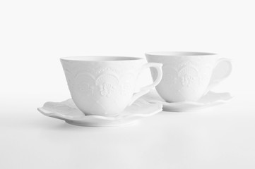 Set of two white elegant porcelain tea cups on white background with clipping path, ready to cut out