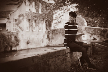 Young girl in hat at bridge in Bruges, Belgium. Autumn season. Image in sepia color style