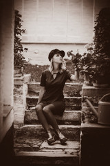 Portrait of a young girl black dress and hat iautumn season garden in Belgium Image in sepia color style