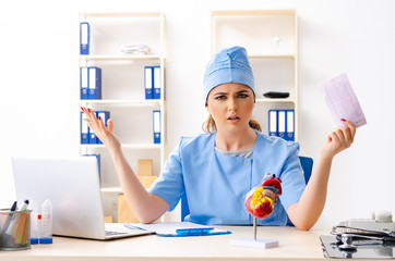Young female doctor cardiologist sitting at the hospital 