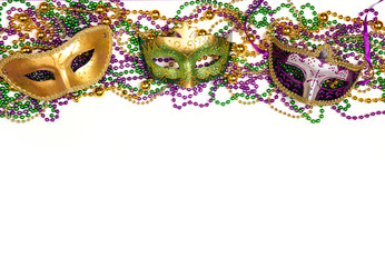 Festive Carnival background with masks, beads and copy space.