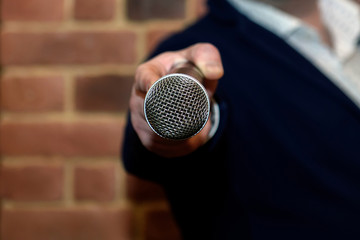 Microphone in the interviewer's hand. Entertainer at the party.  