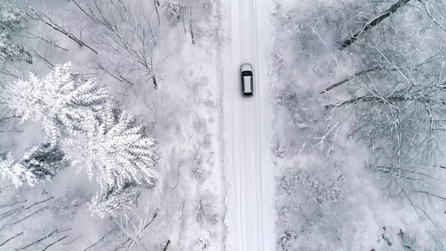 Aerial view of car on road in winter forest