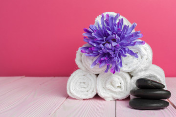 Fototapeta na wymiar clean soft towels with flower on wooden table