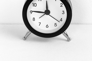 Black vintage alarm clock on a white background close up