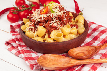 Pasta with meat, tomato sauce and vegetables on the table