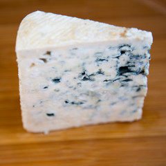 Blue cheese on bamboo board, side view. Close-up.