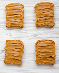 Peanut butter sandwiches on a white wooden table, top view. Close-up.